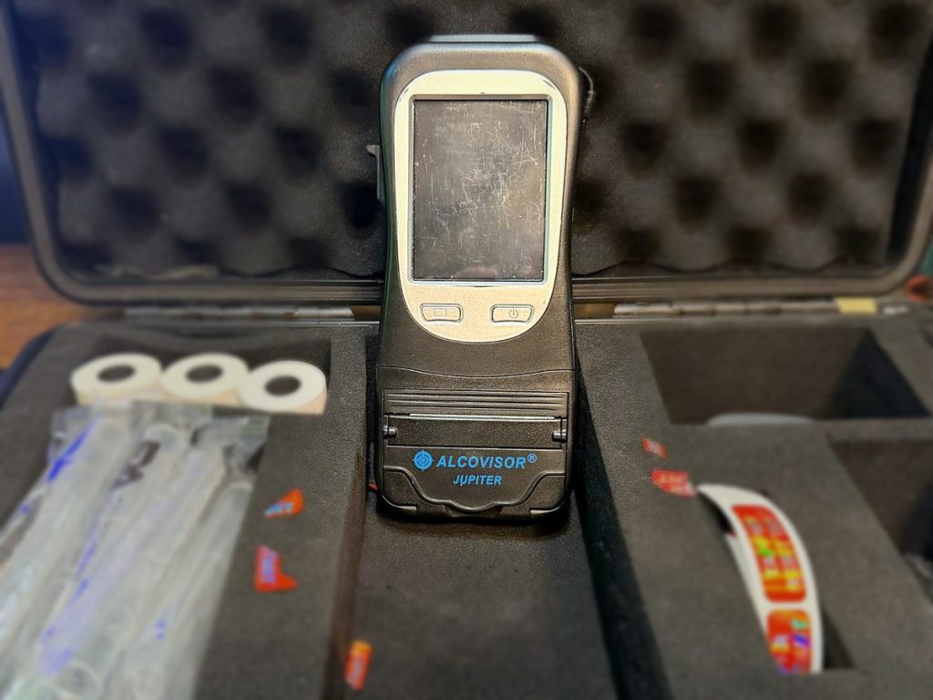 Our Alcovisor Jupiter breathalyzer in its carrying case, with mouthpieces, printer paper and tamper-resistant seals